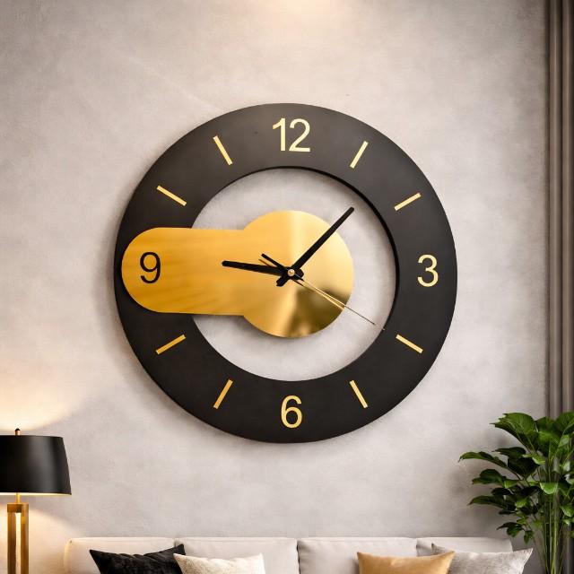 Modern wall clock with black and gold design on a neutral wall.
