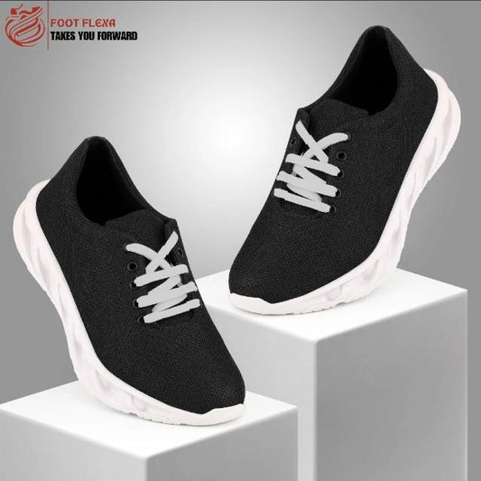 Black running shoes with white laces on a gray background, featuring the 'Foot Flexa' brand.