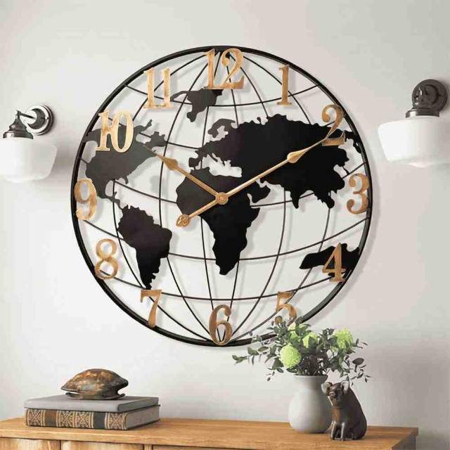 World map wall clock on a white wall with decorative items below.